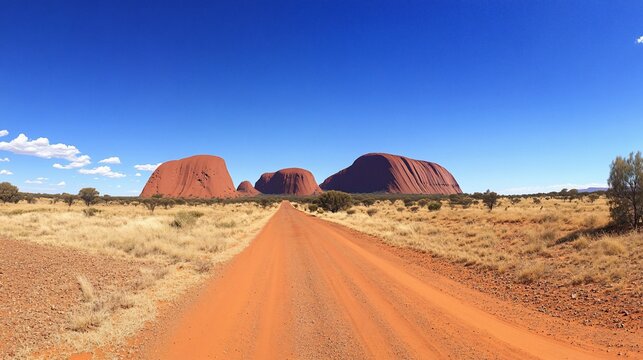 Majestic Uluru Australia Outback: A Scenic Red Dirt Road Journey Towards the Iconic Rock Formation Under a Clear Blue Sky