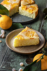 Upside down orange tangerine cake or pie slice on a plate on green wooden background. Fruit citrus pastry. Homemade baking