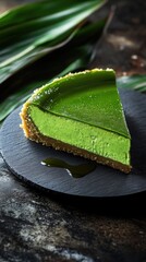 Rich pandan cheesecake with coconut drizzle on matte slate plate enhancing indulgent dessert presentation