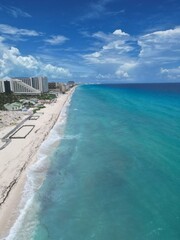 Aerial Top view of a transparent blue sea with beautiful waves at sunny day in summer. Tropical landscape from the air of ocean with azure water, sandy bottom at sunset. Cancun, Mexico.