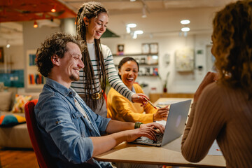 male and female colleagues research together on laptop in the office