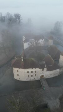 catle  hallwyl  in swizerland in the morning fog 