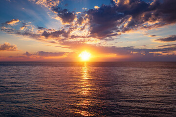 Obraz premium Panoramic beach landscape. Royalty high-quality free best stock of a beautiful sunrise over the ocean with golden sunlight reflecting. Dramatic sky, sense of calm and tranquility