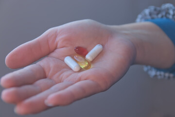 Hand taking vitamins, omega 3, magnesium
