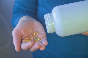 Hand taking vitamins, omega 3, magnesium