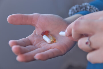 Hand taking vitamins, omega 3, magnesium