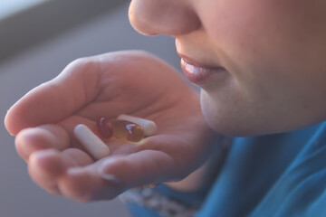Mujer tomando vitaminas, omega 3, magnesio entre otras