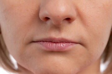 Obraz premium A close-up view of a woman's lips with a neutral expression against a white background.
