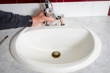 Plumber replaces a bathroom sink faucet