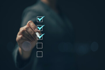 Business performance checklist concept Young business woman using laptop surveys online checklist...