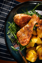 Baked chicken drumsticks with potatoes.