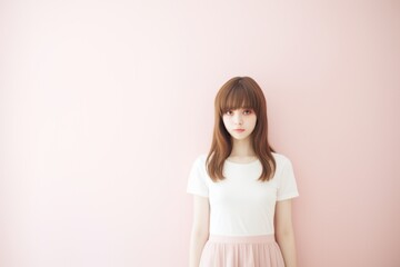 Fototapeta premium A woman is standing in front of a pink wall