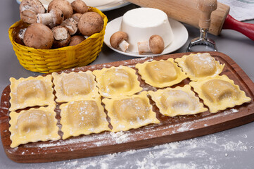 Italian food, fresh home made stuffed pasta ravioli dumplings with ricotta soft cheese and champignons porcini mushrooms, Parma, Emilia Romagna, Italy