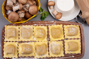Italian food, fresh home made stuffed pasta ravioli dumplings with ricotta soft cheese and champignons porcini mushrooms, Parma, Emilia Romagna, Italy
