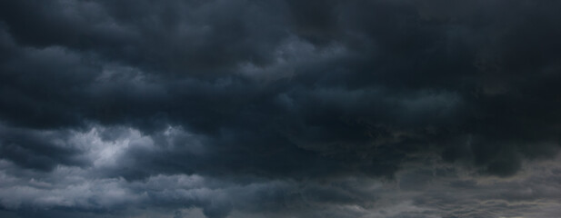 A stormy sky filled with dark, heavy clouds signals an impending windstorm, creating a dramatic and...