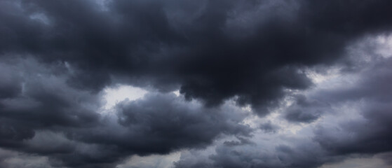 A dark, cloud filled sky creates a foreboding atmosphere, symbolizing the dramatic effects of changing climate patterns and the uncertainties associated with global warming.