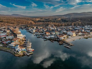 Aerial view of a coastal village with boats and hills