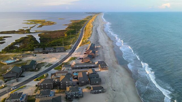 Outer Banks of North Carolina. road goes along the ocean coast in North Carolina. Yellow sand, ocean, cars on the highway. Drone view
