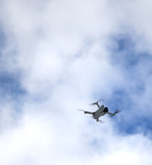 drone flying in the sky next to bare trees in winter (quadcopter aerial photography video videography photo) hover hovering hobby toy aircraft