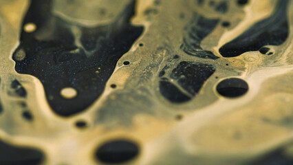 Liquid gel. Blur serum emulsion. Defocused yellow black color shiny glowing viscous texture oil spill drip paint ink water mix on abstract art background.