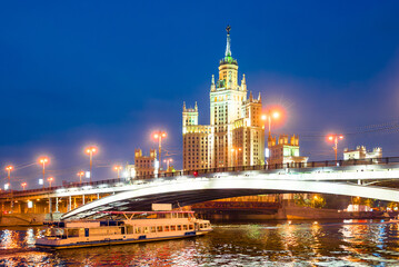 Obraz premium A high-rise building on Kotelnicheskaya embankment and Bolshoy Ustinsky bridge at night. Moscow
