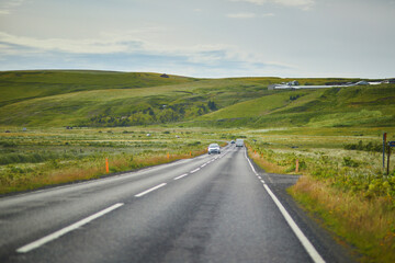 Car driving on a road surrounded by beautiful landscape in Iceland.