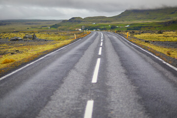 Car driving on a road surrounded by beautiful landscape in Iceland.