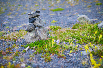 Zen-style stone pyramid with black volcanic mountain landscape in Iceland.