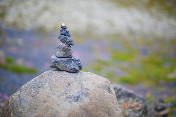 Zen-style stone pyramid with black volcanic mountain landscape in Iceland.