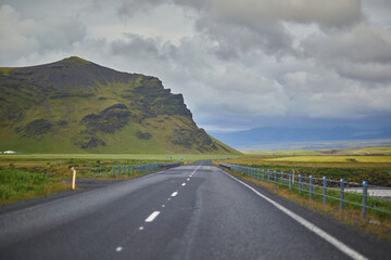 Fototapeta premium Beautiful nature landscape with green fields and majestic cliffs with ice and snow in Southern Iceland.