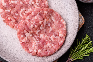 Fresh raw ground beef or pork burger patty with salt and spices