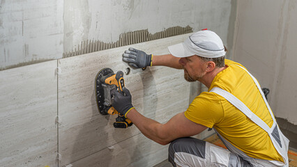 Tiling with large format tiles. A tiler expelling air from under the tile by a vibration suction...
