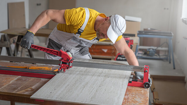 Worker using the tile cutter for cutting gress tile.