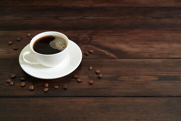 Porcelain Coffee Cup with Black Coffee, Frothy Surface, and Coffee Beans on Rustic Wooden Table