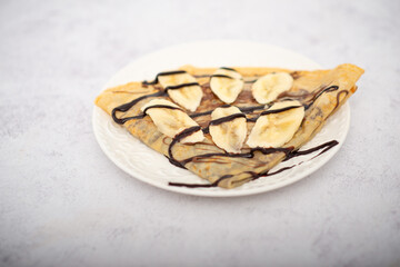 Tasty pancakes with sliced banana served on white table