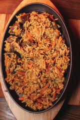 Pilaf in beautiful dishes is on the table in the restaurant. Food served on a stylish black plate