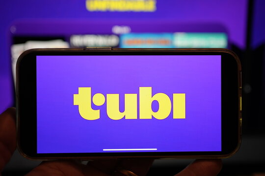 Roosendaal, The Netherlands - February 2, 2025: Amobile phone screen displaying the logo of Tubi, a content streaming platform, with the company website in the background
