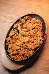 Pilaf in beautiful dishes is on the table in the restaurant. Food served on a stylish black plate