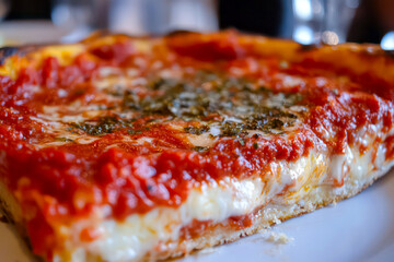 Up-close shot of a cheesy deep-dish pizza slice. 