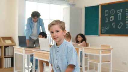 Caucasian cute student looking at camera while friend studying about writing engineering code or...
