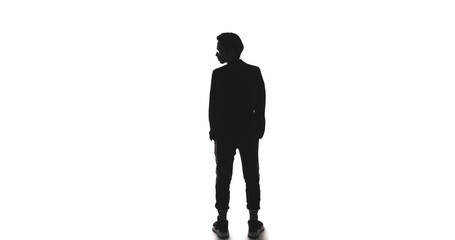 Obraz premium Leader silhouette. Ambition career. Dark contrast back view outline of business man turning head isolated on white empty space background.
