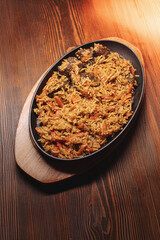 Pilaf in beautiful dishes is on the table in the restaurant. Food served on a stylish black plate