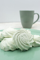 Light green apple marshmallows on a light green plate, close-up