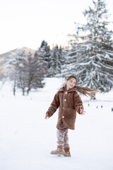 Cute little girl in winter walks in winter snow-covered forest. Winter Activities, Pastime, Walk