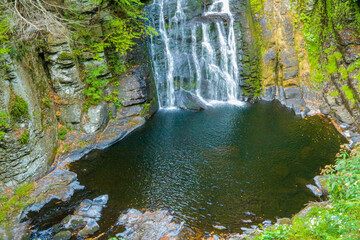 Serene waterfall surrounded by lush greenery at a peaceful natural park perspective This is in Bushkill Falls in Poconos Pennsylvania © Joshua