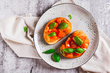 Close up of  bruschetta with tomatoes, garlic and basil on a plate on the table top view