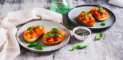 Appetizing bruschetta with tomatoes, garlic and basil on a plate on the table web banner