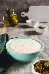 Traditional ranch dressing made with cottage cheese and pickles in a bowl vertical view