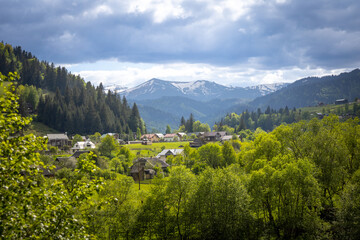 Beautifull ukrainian village Verhovina in spring with mountain with snow.