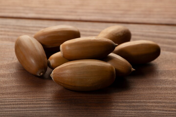Oak acorns on a wooden background. Natural products.